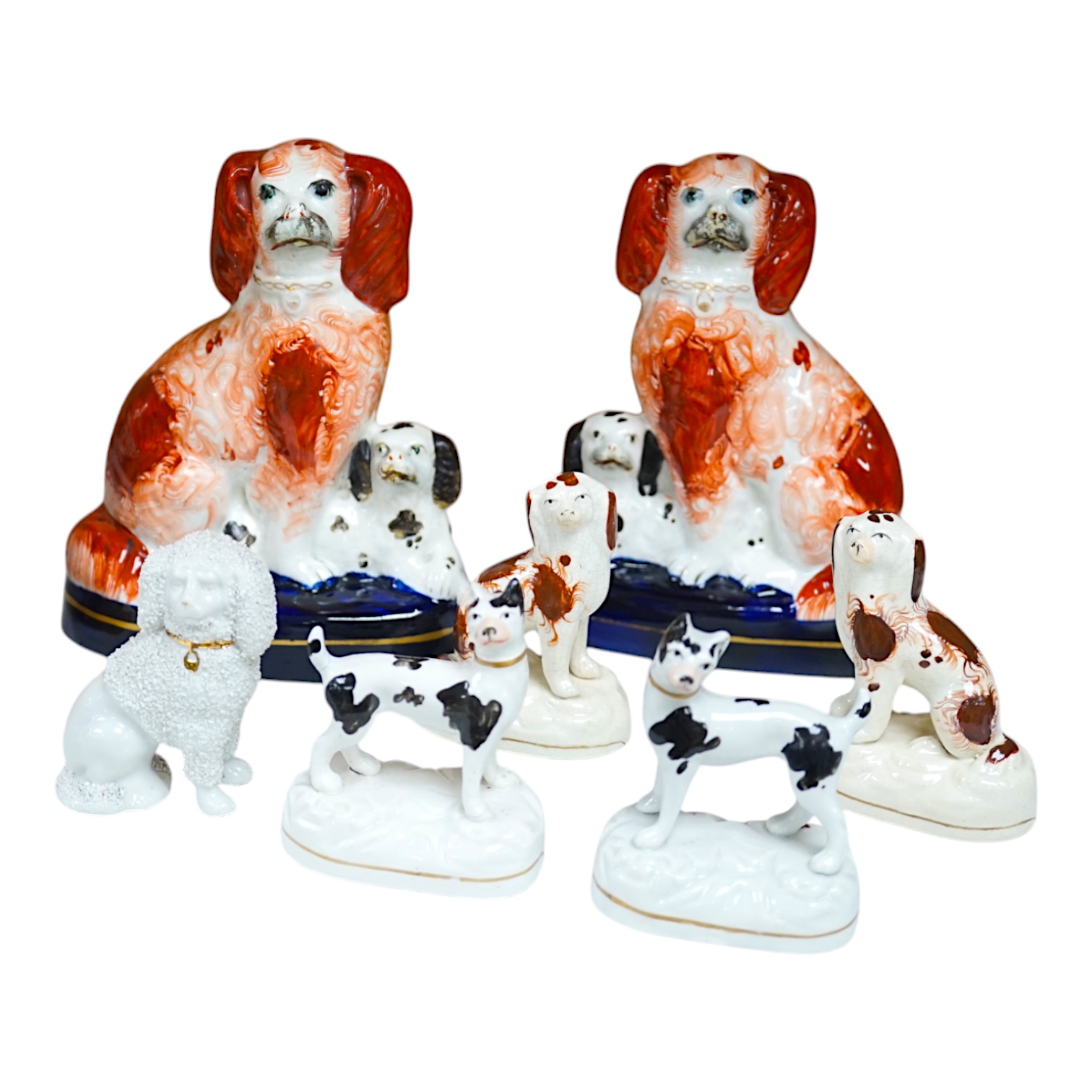 A pair of mid 19th century Staffordshire spaniel and puppy groups, a pair of smaller Staffordshire spaniel figures, and a pair of Staffordshire porcelain figures of standing terriers, c.1835, together with a Continental